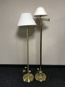 A pair of brass floor lamps with shades
