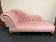 A contemporary chaise longue in pink button fabric
