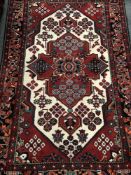 A Caucasian design rug on red ground,