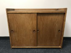 A mid 20th century teak sliding door cabinet