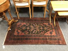 A Persian Baluchi rug, on rust ground, 87 cm x 142 cm.