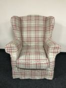 A wing back armchair with tartan loose covers
