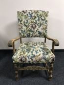A carved continental oak armchair in floral fabric