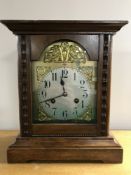 A stained pine cased German mantel clock with brass dial