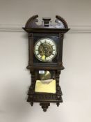 An early 20th century mahogany cased eight day wall clock with pendulum and key