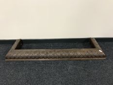 An early 20th century heavily carved oak fire curb