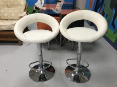 A pair of cream leather gas lift bar stools