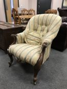 A Victorian carved walnut armchair upholstered in striped fabric,