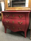 A pink painted three drawer Bombe chest,