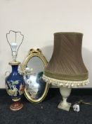A small oval gilt framed mirror, marble table lamp and shade,