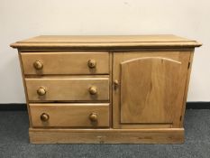A Victorian pine low cupboard fitted with three drawers,