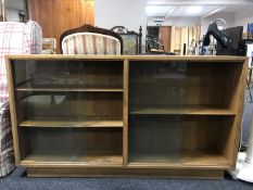 A mid 20th century oak sliding door bookcase