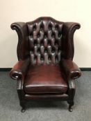 An oxblood leather Chesterfield wing armchair,
