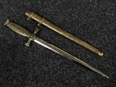 An ornamental brass handled dagger in sheath