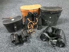 Three pairs of binoculars in leather cases,
