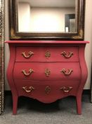 A pink painted three drawer Bombe chest,