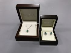 An 18ct white gold emerald and diamond cluster pendant on chain,