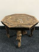 A carved Eastern walnut table with inlaid decoration with elephant head supports