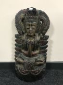 A carved hard wood painted figure on an Eastern god.