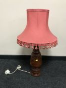 A carved wooden table lamp with shade