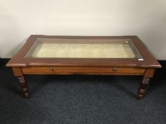 A contemporary glass topped bijouterie coffee table