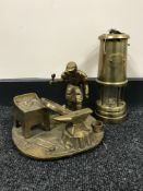 A brass Lime Light miner's lamp and a brass ornament of a wheel right