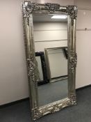 A very large silvered overmantel mirror in ornate frame,