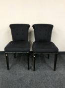 A pair of black upholstered button back chairs