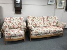 An Ercol three seater settee with matching armchair upholstered in floral fabric