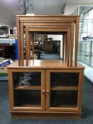 A nest of three late 20th century teak tables and a Meredew double door cabinet