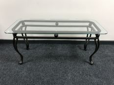 A cast metal glass topped coffee table