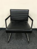 A contemporary chrome framed black leather armchair