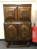 An early 20th century carved oak cocktail cabinet with slide and double cupboards,