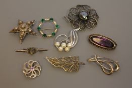A collection of silver brooches
