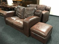 A pair of brown leather two-seater settees with matching footstool