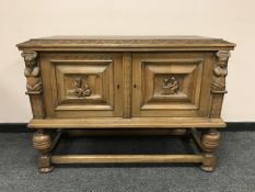 A carved oak low cabinet with double doors,