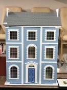 A Georgian style doll's house and a small wicker doll's pram