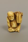 A Japanese ivory netsuke depicting a seated gentleman,