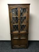 A carved oak double door corner cabinet