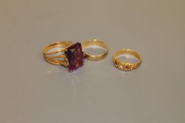 An 18ct gold ruby and diamond ring, a 9ct gold band ring and a gold ring set with a large amethyst,