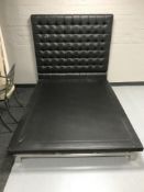 A contemporary black button leather 4'6 bed frame on metal legs