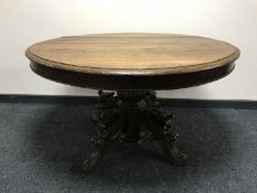 A late 19th century French oak dining table on a heavily carved oak pedestal