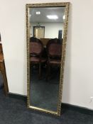 A gilt framed rectangular mirror with bevelled glass, 44.5 cm x 126.5 cm.