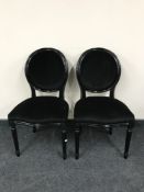 A pair of black upholstered salon chairs