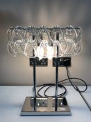 A contemporary chrome table lamp with glass drops