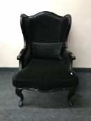 A contemporary wing back armchair in black fabric