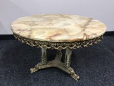 A good quality variegated onyx coffee table, on brass tri-form base, with onyx pillars, width 75 cm.
