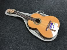 A Spanish acoustic guitar in carry bag and a hands free auto tuner