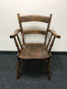 An antique pine kitchen armchair