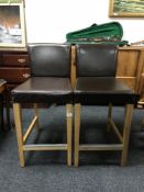 A pair of brown leather bar stools